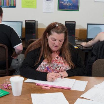 GED Student takes notes on her pink notebook