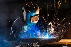 Welder wears heavy gear as they craft their material